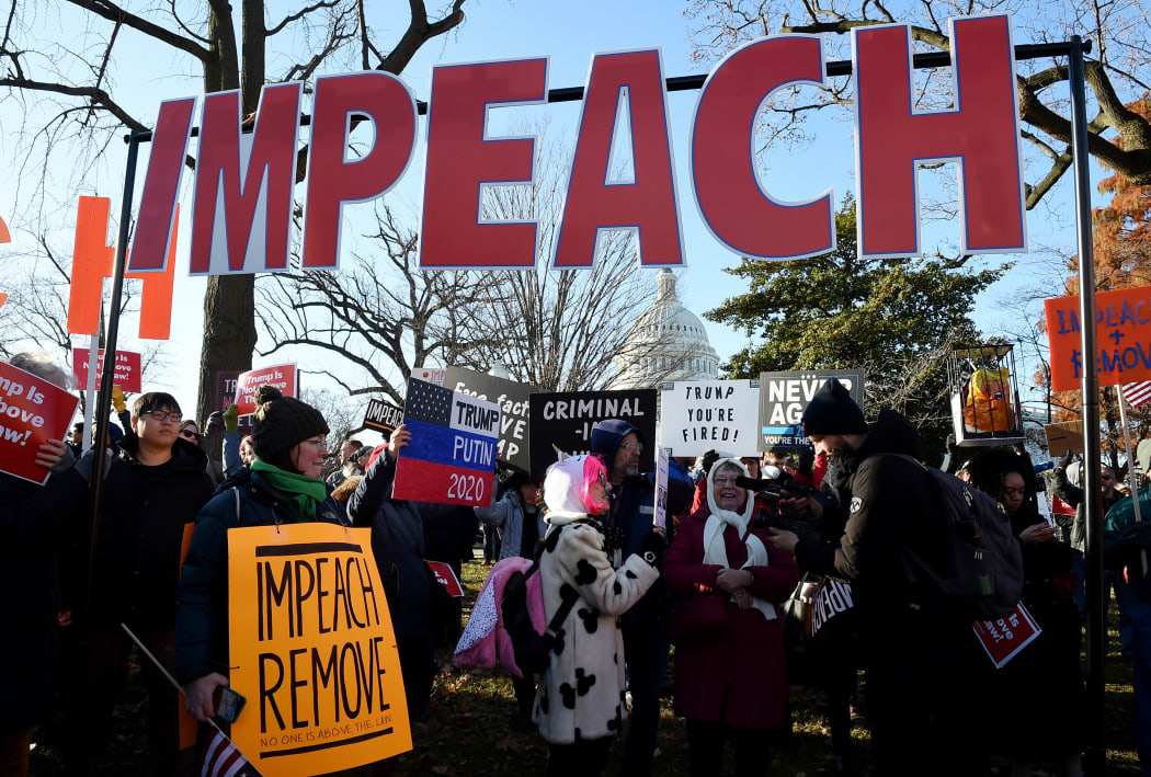 People rally in support of the impeachment of US President Donald Trump in front of the US Capitol, as the House readies for a historic vote on December 18,  2019  that would trigger his trial in the Senate.