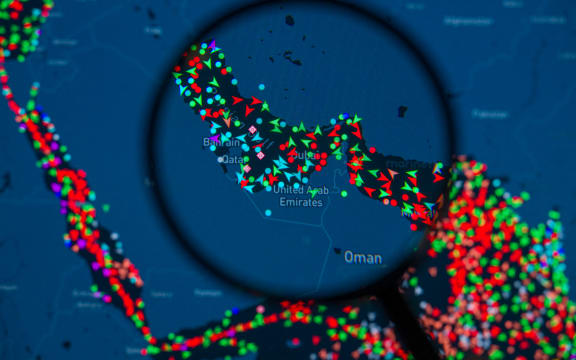 A MarineTraffic map showing ship movements in the Strait of Hormuz is pictured through a magnifying glass in this photo illustration, as commercial vessel traffic through the key oil shipping lane drops sharply amid the escalating conflict involving Iran. Taken in Brussels, Belgium, on March 15, 2026. (Photo by Jonathan Raa/NurPhoto) (Photo by Jonathan Raa / NurPhoto via AFP)