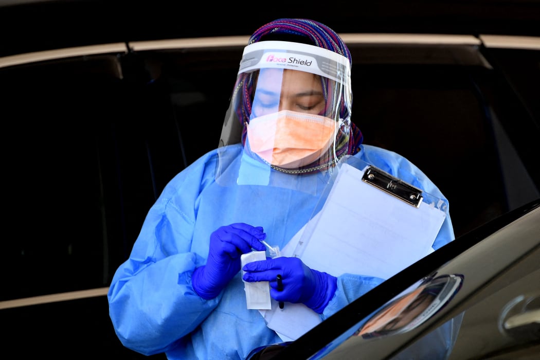 A health worker takes a swab sample at a Covid-19 drive-through testing site in western Sydney on August 7, 2021.