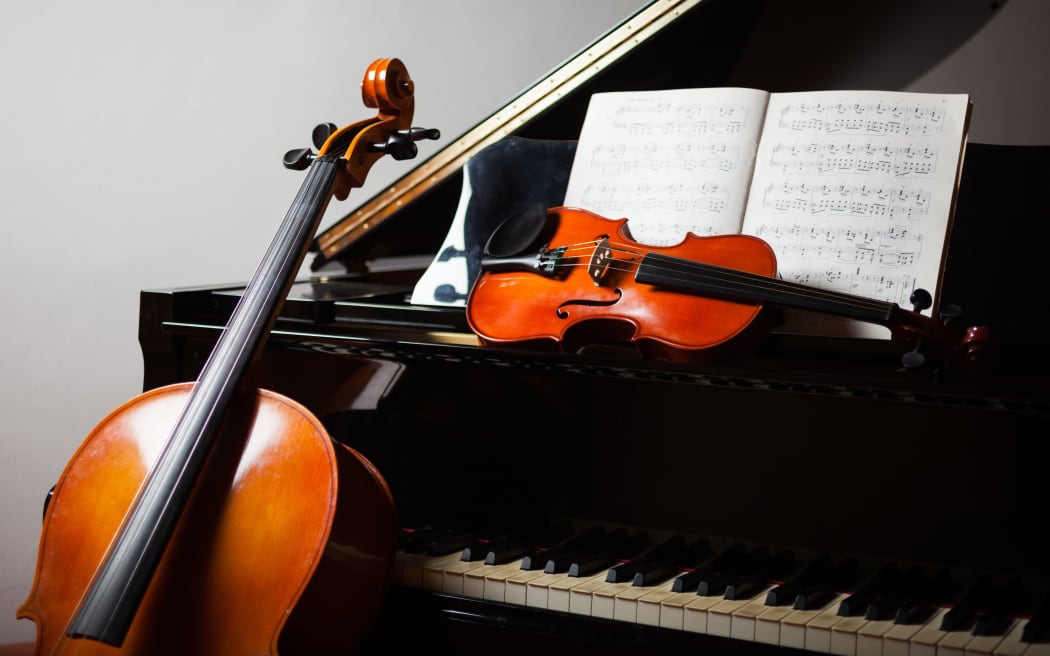 Classical music concept: cello, violin, piano and a score