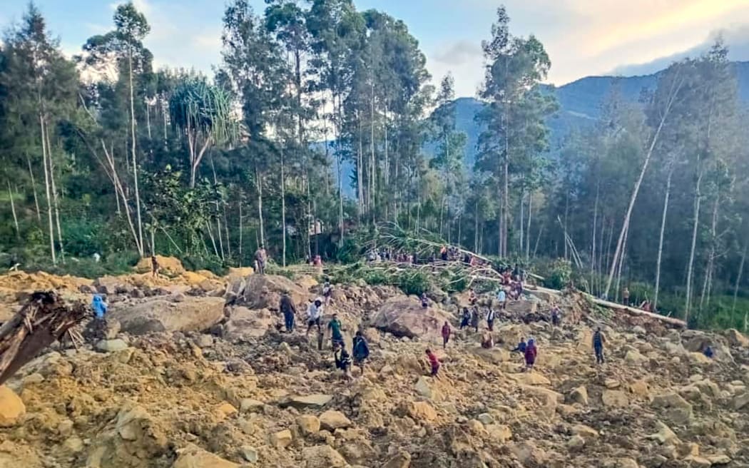 People gather at the site of a landslide in Maip Mulitaka in Papua New Guinea's Enga Province on May 24, 2024. Local officials and aid groups said a massive landslide struck a village in Papua New Guinea's highlands on May 24, with many feared dead.