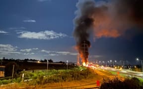 A truck carrying canisters containing highly flammable gas in flames on Auckland's southern motorway on 8 March 2023.