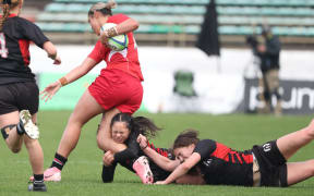 Asha Taumoepeau-Williams of Howick College is tackled by Araia Keighley-Rein of Manukura.