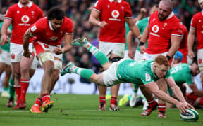 Ireland's full back Ciaran Frawley dives over the line to score a try during the Six Nations international rugby union match between Ireland and Wales at the Aviva Stadium in Dublin, on February 24, 2024. (Photo by Paul Faith / AFP)