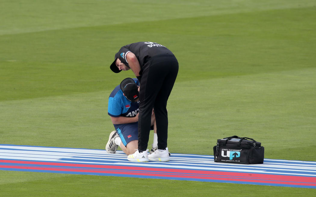 Tim Southee of New Zealand has his injured hand tended to by a physio