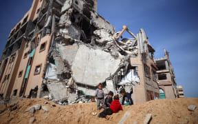 Displaced Palestinian children are seen inside the destroyed Islamic University in Gaza City, Gaza, on March 25, 2025. Israel vows to destroy the Palestinian militant group Hamas and on March 18 resumes intense bombardment of Gaza and redeploys ground troops, shattering a truce that has largely held since January 19. (Photo by Majdi Fathi/NurPhoto) (Photo by MAJDI FATHI / NurPhoto / NurPhoto via AFP)
