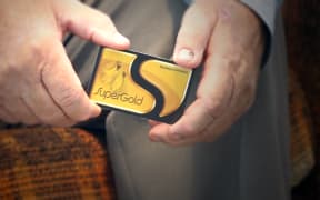 A super gold card held in someone's hands.