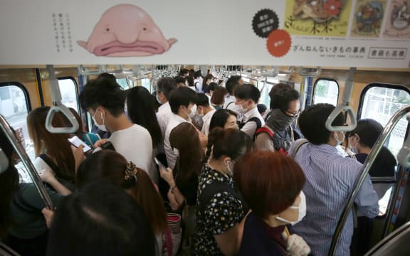 An inside of train is packed with passengers on a JR Line  during a rush hour in Ota Ward, Tokyo  on June 15, 2020,