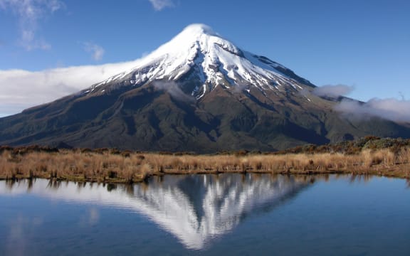 A view of Mt Taranaki over a waterway.