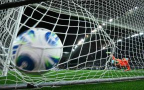 Tottenham Hotspur's Italian goalkeeper Guglielmo Vicario dives the wrong way as PSG successfully score a penalty during the penalty shootout at the end of the 2025 UEFA Super Cup final.