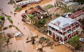 People walk on the flooded street of Buzi, central Mozambique, on March 20, 2019 after the passage of the cyclone Idai.