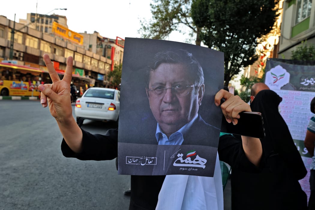 A supporter of Iran's reformist candidate Abdolnasser Hemmati holds his portrait.