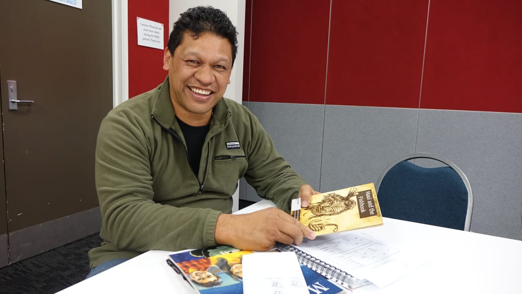 Male te reo teacher at table