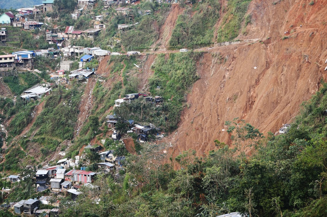 Philippine rescuers used shovels and their bare hands to claw through mounds of rocky soil, as they desperately looked for dozens of miners feared buried beneath a landslide unleashed by Typhoon Mangkhut.