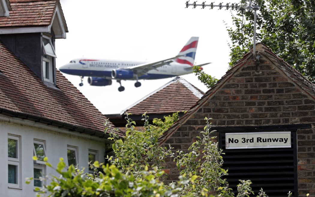 A sign in the village of Longford opposing Heathrow expansion, pictured as a British Airways aircraft prepares to land at the west London airport.