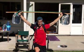NZ high jumper Hamish Kerr training with water bottles during lockdown.