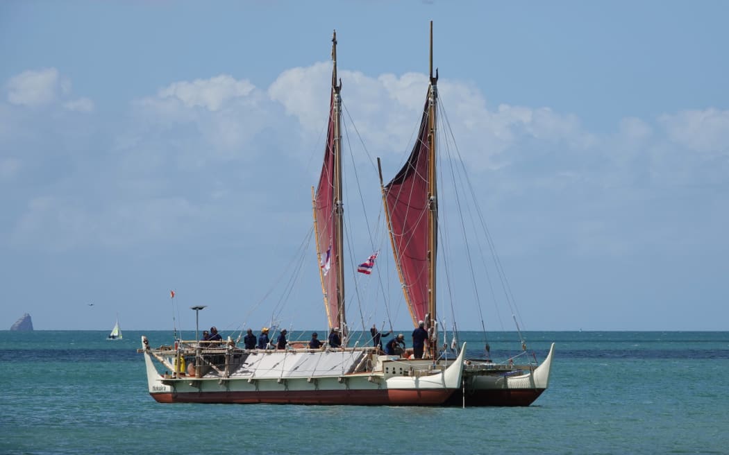 The wa’a (waka) Hōkūle’a anchors in Tii Bay.
