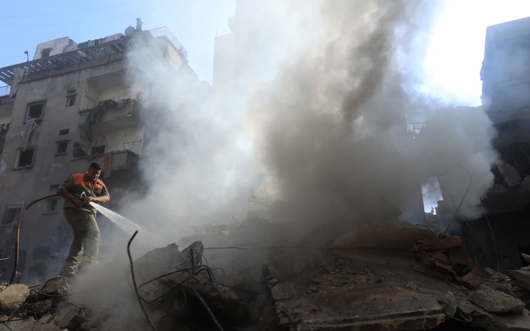 Members of the Lebanese civil defence battle a fire at the site of an Israeli strike on Beirut's Basta neighbourhood on October 11, 2024. - At least 22 people were killed in Israeli strikes on a densely populated area of central Beirut on October 10, the Lebanese health ministry said, with a security source saying a Hezbollah figure was the target. (Photo by AFP)