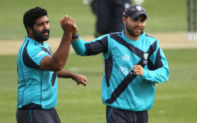 Majid Haq of Scotland celebrates with Preston Mommsen after taking a wicket.
