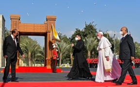 Pope Francis walks alongside Iraqi President Barham Saleh (right) during a welcome ceremony at the presidential palace in Baghdad on 5 March.