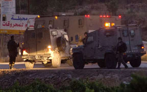 Israeli soldiers at the village of Halhul, near Hebron, where the bodies were found.