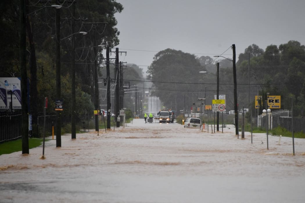 This picture shows a main road of a residential area flooded during heavy rain in western Sydney on March 20, 2021, amid mass evacuations being ordered in low-lying areas along Australia's east coast