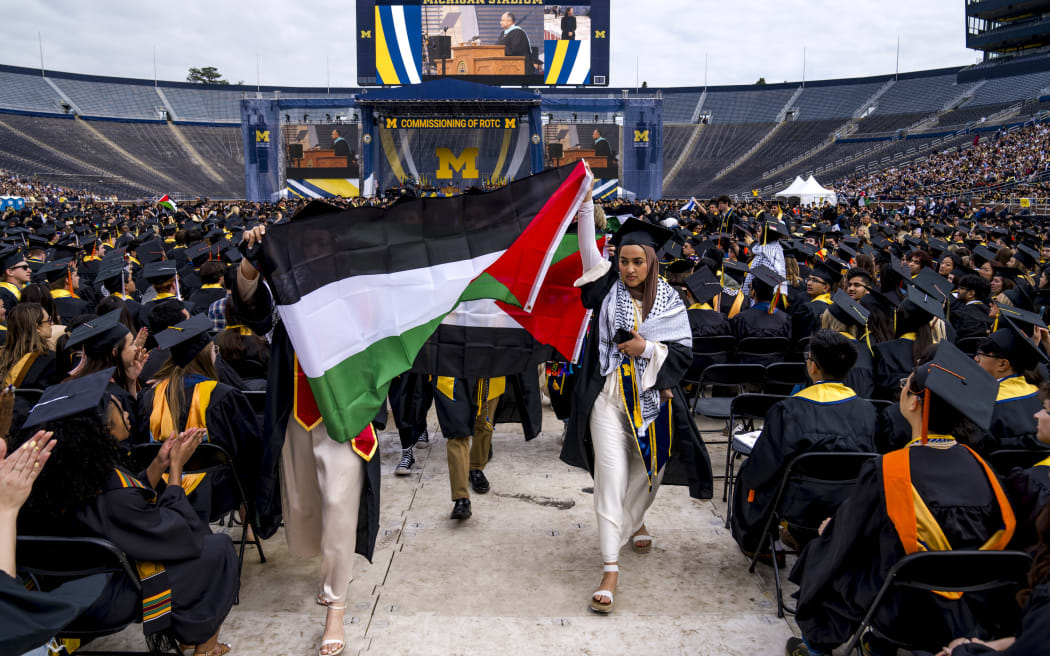 ANN ARBOR, MICHIGAN - MAY 4: Salma Hamamy carries a Flag of Palestine during a Pro-Palestinian protest during the University of Michigan's Spring Commencement ceremony on May 4, 2024 at Michigan Stadium in Ann Arbor, Michigan. A group of students called for the University of Michigan to divest from companies with ties to Israel during the spring commencement ceremony.   Nic Antaya/Getty Images/AFP (Photo by Nic Antaya / GETTY IMAGES NORTH AMERICA / Getty Images via AFP)