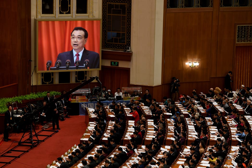 Chinese Premier Li Keqiang is shown on a screen as he delivers his work report during the opening session of the National People's Congress.