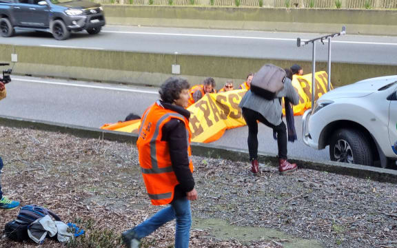 Protesters, believed to be climate activists, wearing high-viz vests are blocking the southbound lane of Wellington's Terrace Tunnel while police work to remove them.