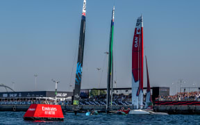New Zealand SailGP Team helmed by Peter Burling, Australia SailGP Team helmed by interim driver Jimmy Spithill and Canada SailGP Team helmed by Phil Robertson cross the finish line on Race Day 2 of the Emirates Sail Grand Prix in Dubai, United Arab Emirates on 10 December, 2023.