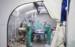 Red Cross staff operate on a baby boy in the field hospital. Credit: Emilia Kangasluoma/IFRCNo caption