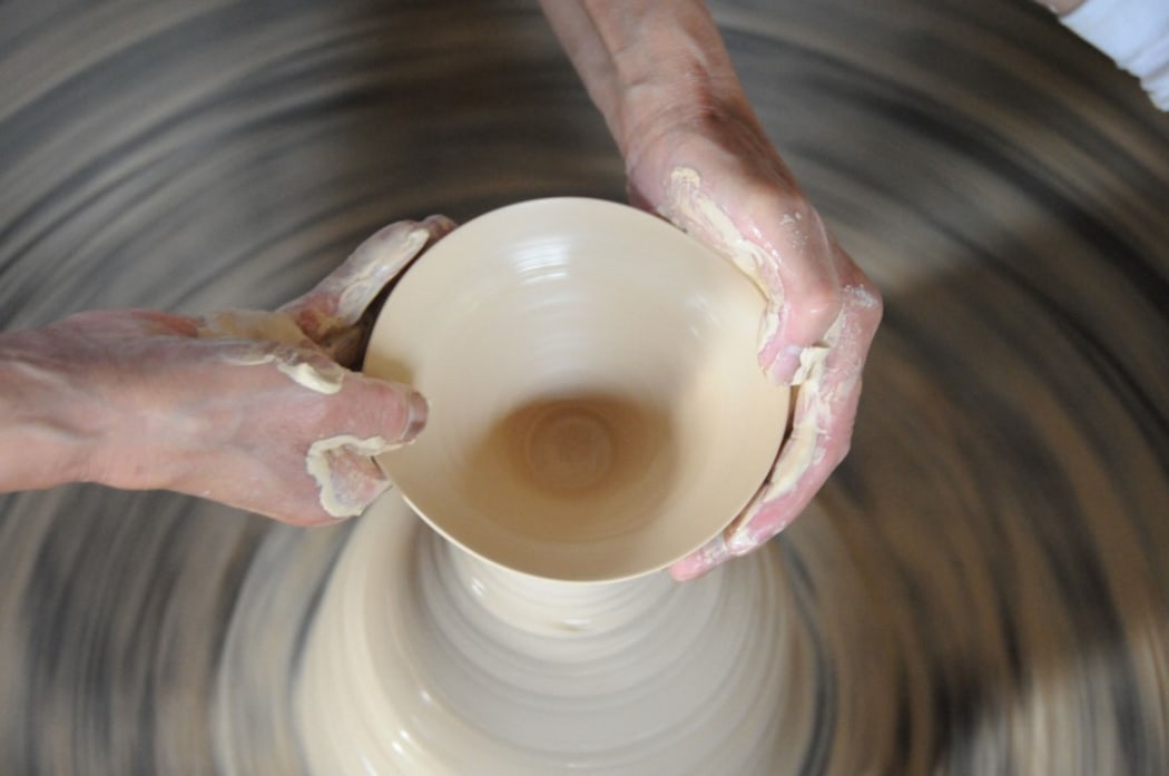 eteran craftsman Wang Yansheng does throwing on a potters' wheel in an old kiln in Jingdezhen City, east China's Jiangxi Province.
