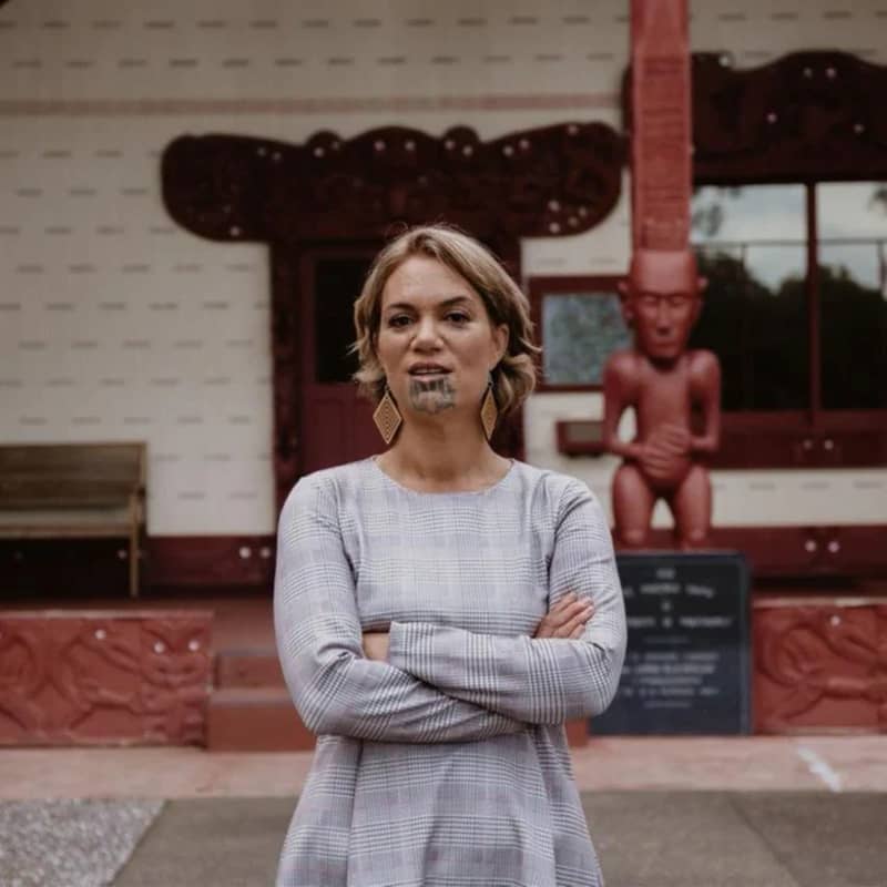 Heeni Hotorene stands with her arms crossed on the forecourt of Te Whare Rūnanga at the historic Waitangi Treaty grounds.