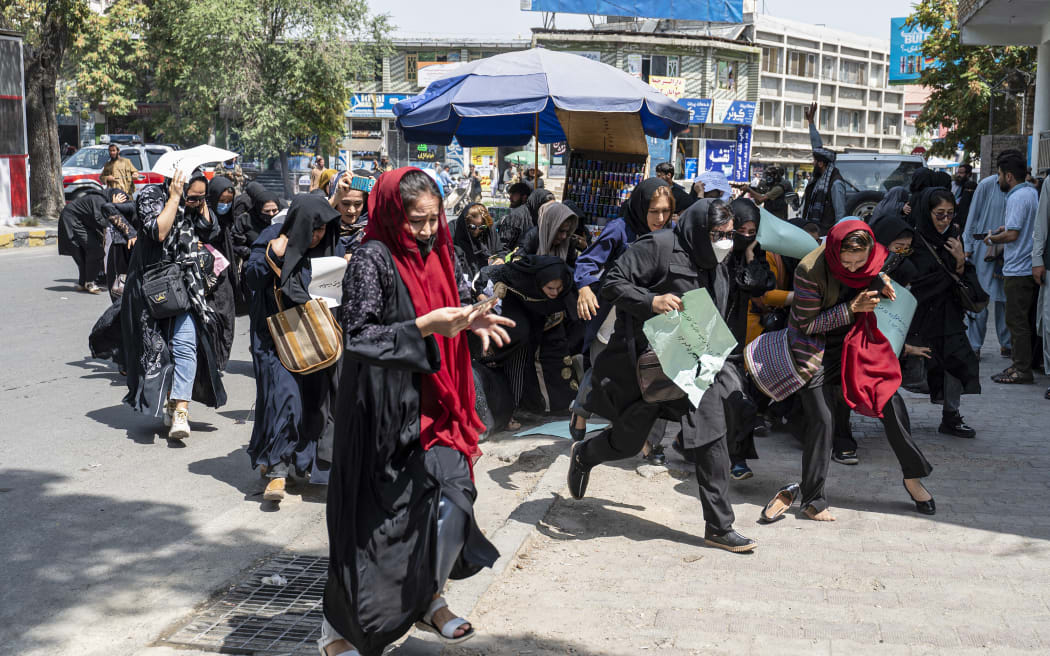 Taliban fighters fire into the air to disperse Afghan women protesters in Kabul on August 13, 2022. - Taliban fighters beat women protesters and fired into the air on Saturday as they violently dispersed a rare rally in the Afghan capital, days ahead of the first anniversary of the hardline Islamists' return to power. (Photo by Wakil KOHSAR / AFP)
