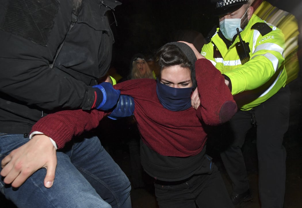 Police officers scuffle with people gathering at a band-stand where a planned vigil in honour of murder victim Sarah Everard was cancelled after police outlawed it due to Covid-19 restrictions.