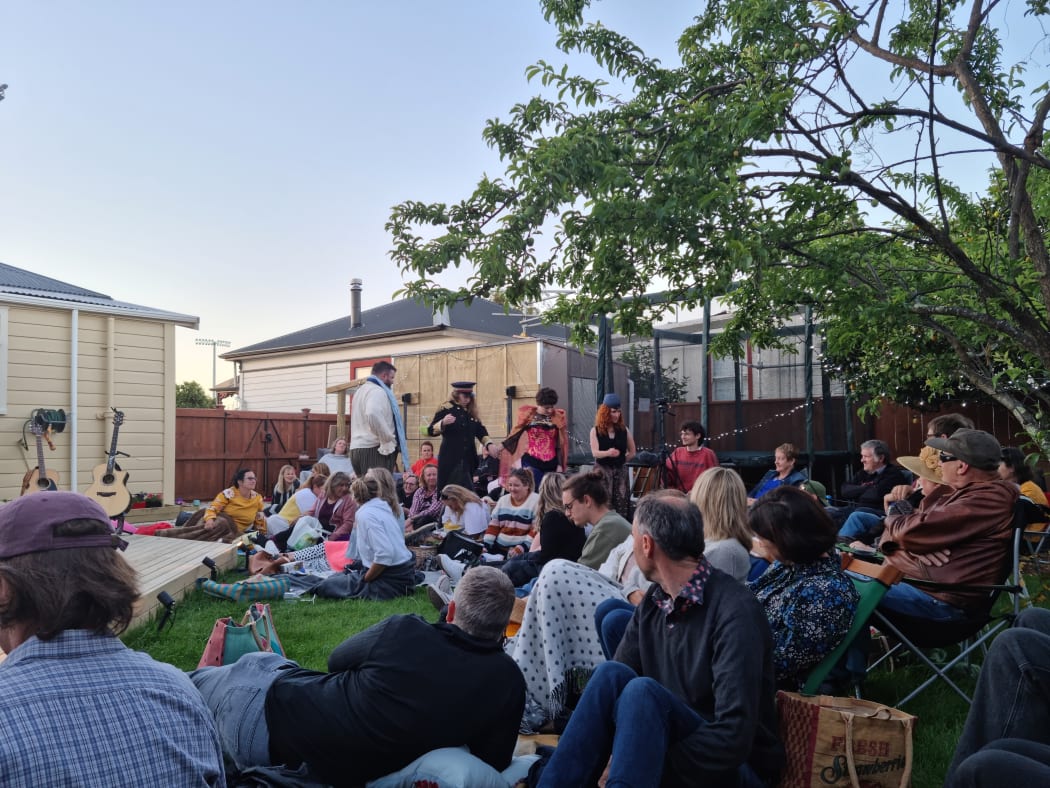 Cast members of A Midsummer Night’s Dream follow Puck through the crowd during a backyard show in Nelson.