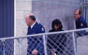 Ziggy Stardust Buckeridge, 61, clutches a Bible while being escorted to court during his trial for the murder of 14-year-old schoolgirl Julie Sands.