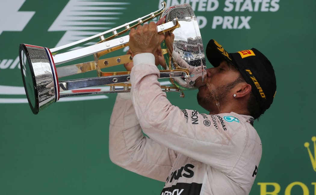 Lewis Hamilton celebrates on the winners podium.