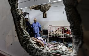 (FILES) People inspect the damage in a room following Israeli bombardment at Nasser hospital in Khan Yunis in the southern Gaza Strip on December 17, 2023, amid ongoing battles between Israel and the Palestinian militant group Hamas. Medics are sounding the alarm at southern Gaza's Nasser hospital, where a nurse said snipers are killing people, sewage has flooded the emergency room and drinking water has run out. Fighting between Israeli soldiers and Hamas militants has taken place all around Nasser hospital in the southern Gazan city of Khan Yunis. (Photo by AFP)