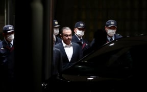 Carlos Ghosn is escorted from the Tokyo detention house after his release.