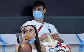 British diver Thomas Daley sits with his knitting as he watches divers in the preliminary round of the men's 3m springboard diving event during the Tokyo 2020 Olympic Games at the Tokyo Aquatics Centre in Tokyo on August 2, 2021.