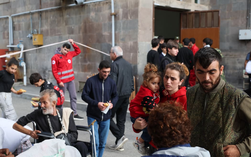 Refugees wait in front of Red Cross registration center in Goris, on September 25, 2023. The first group of Nagorno-Karabakh refugees since Azerbaijan's lighting assault against the separatist region entered Armenia on September 24, 2023, an AFP team at the border said. The group of a few dozen people passed by Azerbaijani border guards before entering the Armenian village of Kornidzor, where they were registered by officials from Armenia's foreign ministry. (Photo by ALAIN JOCARD / AFP)