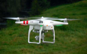 A drone near the woods.