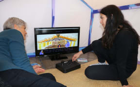 Kahurangiariki Smith, (right), with her mother Aroha, plays the Māori Grl video game.