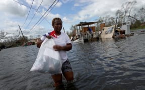 Dina Lewis rescues items from her home in Laplace, Louisiana, which was destroyed by Hurricane Ida on 30 August 2021