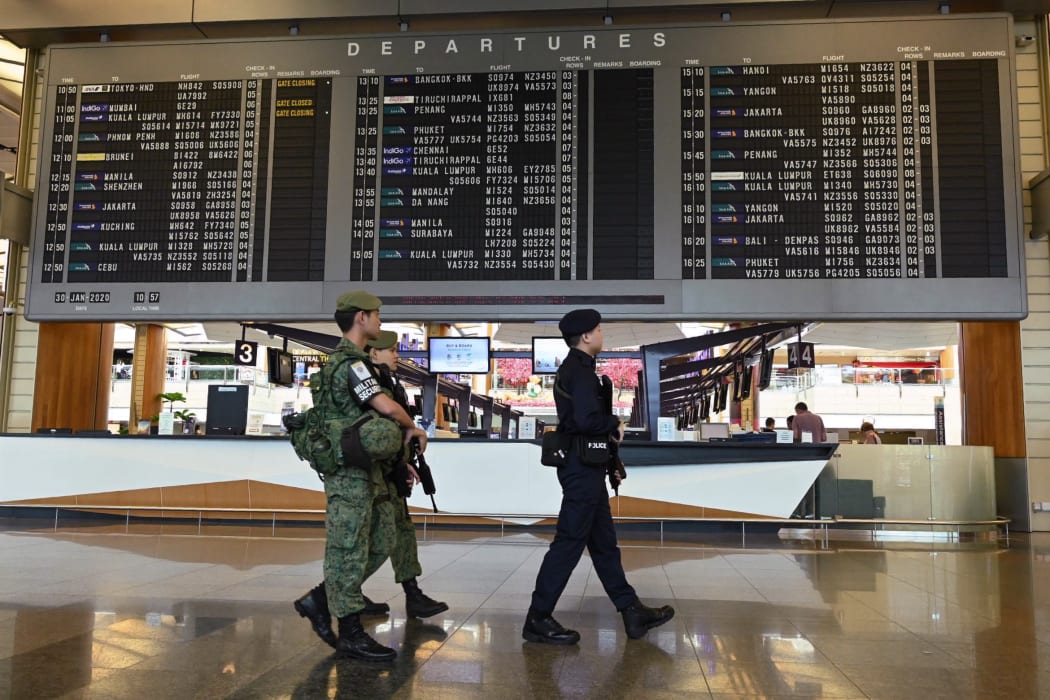 Armed military and police personnel patrol at Changi international airport terminal in Singapore on 30 January 2020.