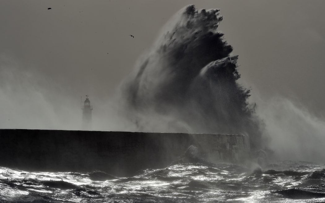 Waves crash over Newhaven Lighthouse on the south coast of England on February 23, 2017 as Storm Doris hits the country.