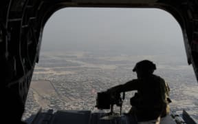 A file photo of a soldier in a helicopter flying over Kabul.