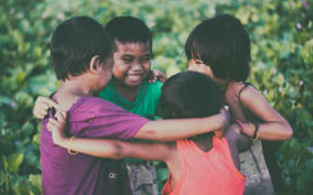 four children hug