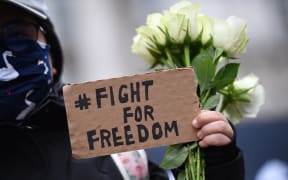 A protester holds a small placard at an event organised by Justitia Hong Kong to mourn the loss of Hong Kong's political freedoms